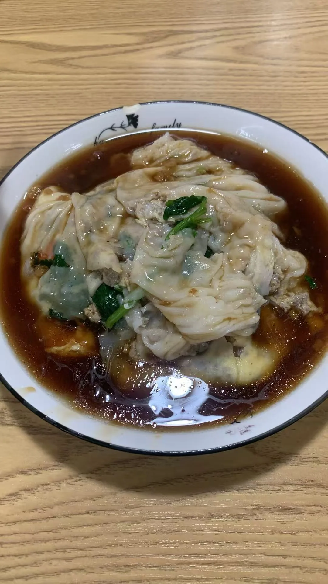 In Chaozhou: Rice noodle rolls with greens and filling in a pool of brown sauce / 在潮州拍摄：浸在褐色酱汁中的肠粉，薄粉皮里露出青菜和馅料